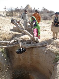 Family at the water well in Pakistan.